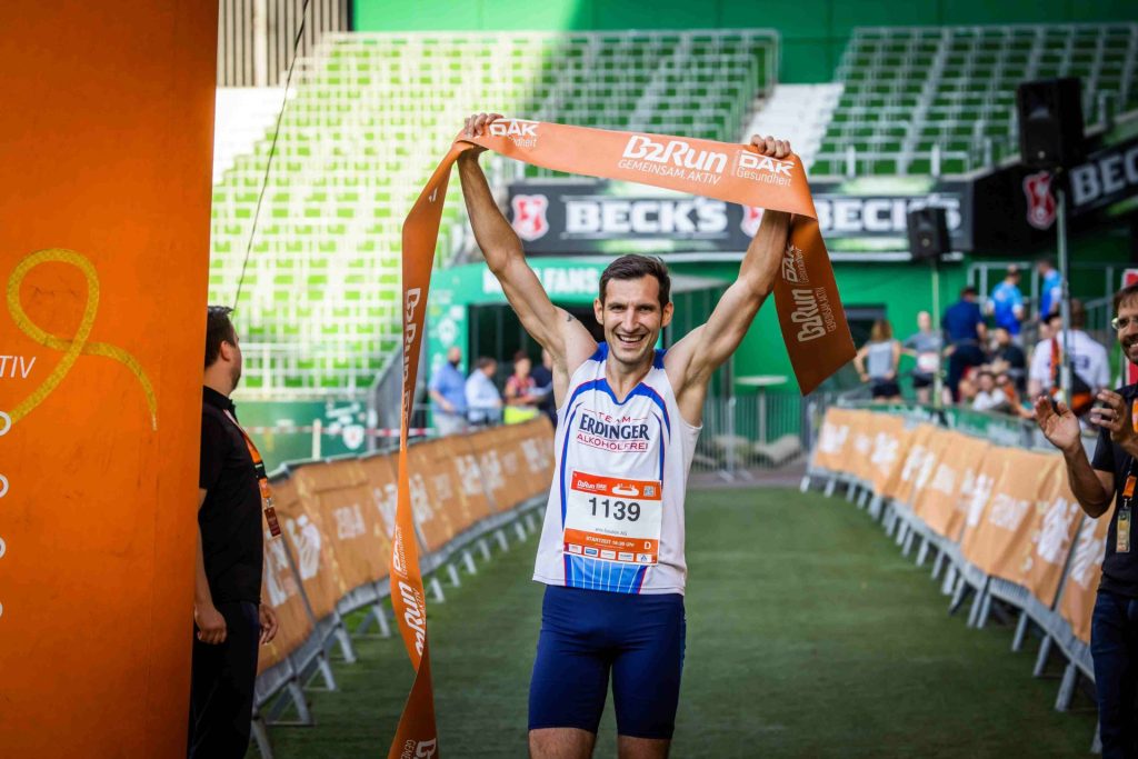 Läufer mit Siegerbänder glücklich